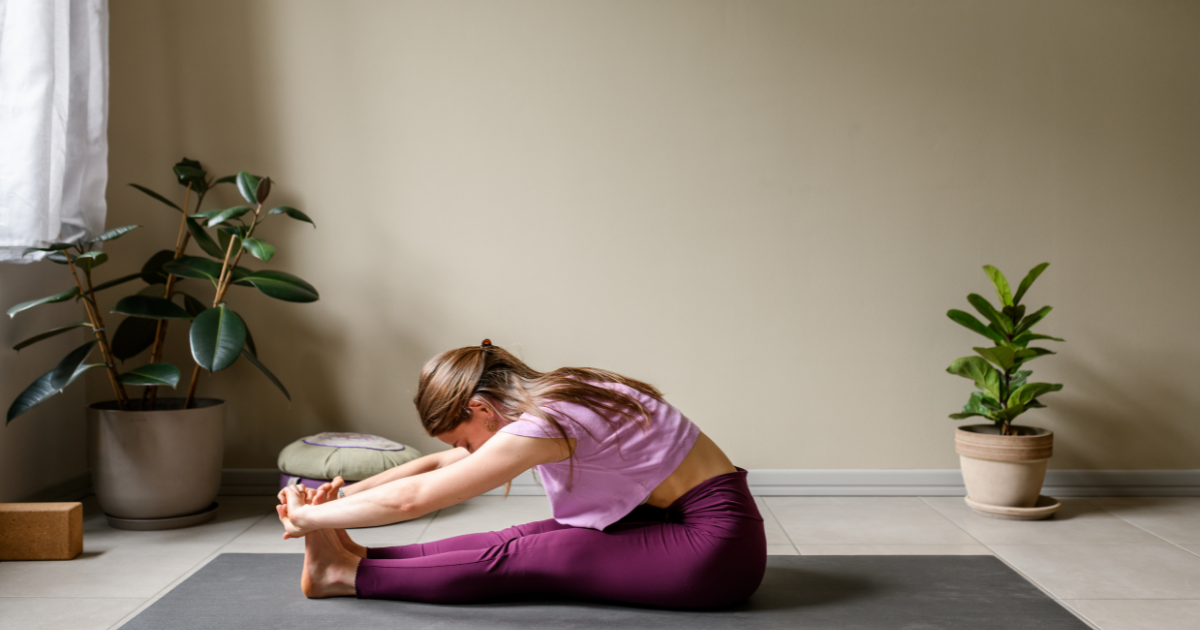 Persona che fa yoga su un tappetino in salotto